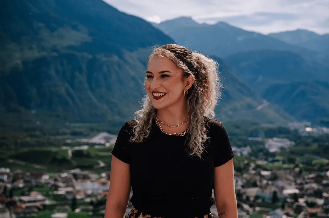 Alisha Cina in a black shirt, smiling in front of the Rhone valley